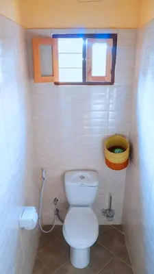 a small bathroom with a toilet and a window at Osotwa Maasai Hostel in Arusha