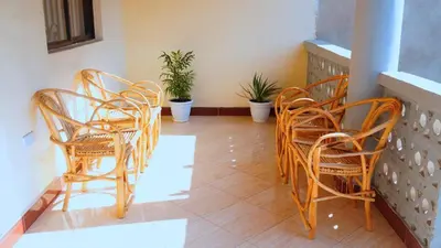 a group of chairs and tables on a balcony at Osotwa Maasai Hostel in Arusha