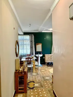 a living room with a table and chairs in it at we are one apartment in Arusha