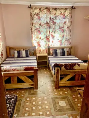 a bedroom with two beds and a window at we are one apartment in Arusha