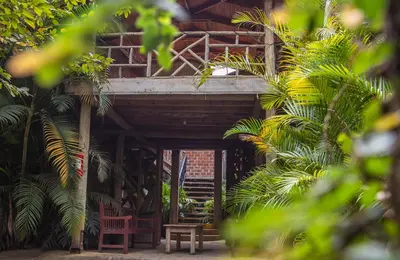 a building with a balcony with chairs and trees at Christina House in Arusha