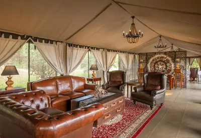 a living room with leather furniture in a tent at TARANGIRE KURO TREETOP LODGE in Manyara