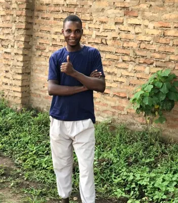 a man standing in front of a brick wall at Zimbe Host Arusha in Arusha