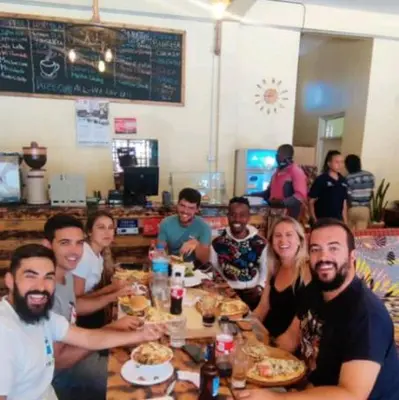 a group of people sitting at a table eating food at Zimbe Host Arusha in Arusha