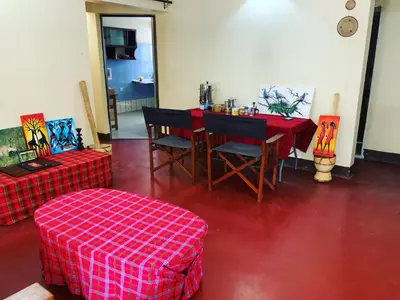 a room with a table and chairs and a red floor at Manyada Inn in Arusha