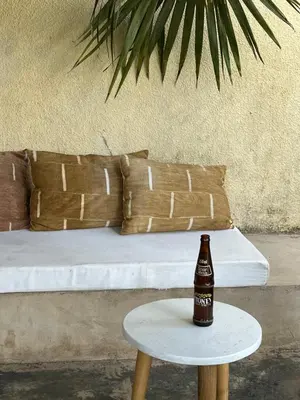 a bottle of beer sitting on a table next to a bed at Stasumo House Arusha in Arusha