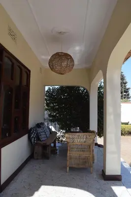 a patio with a table and a chandelier at Stasumo House Arusha in Arusha