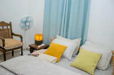 a room with a bed with pillows and a fan at Blue elephant villas in Arusha