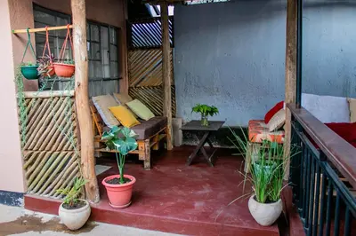 a balcony with a couch and a table and plants at Blue elephant villas in Arusha