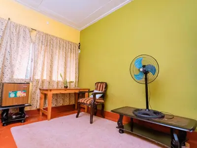 a room with a fan and a table and a desk at FARAJA HOMESTAY- Seamless Comfort in the Heart of the City - Free WiFi, Warm Hospitality, and Local Delights Await in Moshi