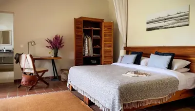 a bedroom with a bed and a desk and a chair at Katambuga House in Arusha