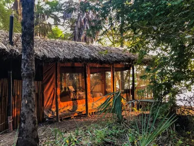 a resort cabin with a thatched roof at Kisima Ngeda Camp in Mangola