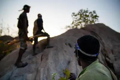 two men standing on top of a rock at Kisima Ngeda Camp in Mangola