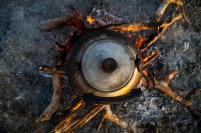 a metal pot sitting on top of a fire at Kisima Ngeda Camp in Mangola