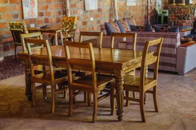 a wooden table and chairs in a room at Kilimanjaro Scenic Homestay in Moshi