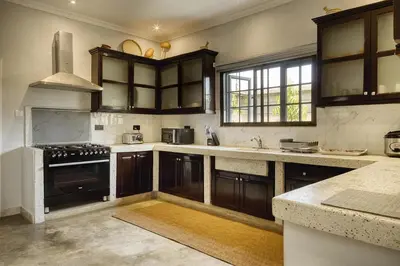a kitchen with wooden cabinets and a stove top oven at Sarita Village Homes in Arusha