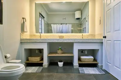a bathroom with a toilet and a sink and a mirror at Sarita Village Homes in Arusha