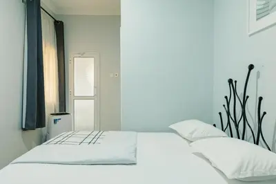 a white bed with white pillows in a room at Sarita Village Homes in Arusha