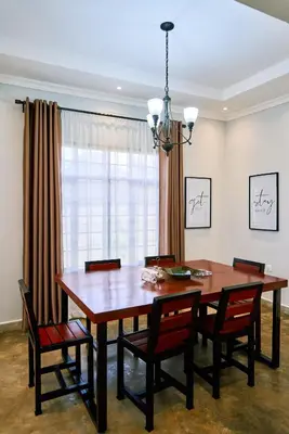 a dining room table with chairs and a chandelier at Sarita Village Homes in Arusha