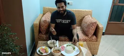 a man standing in front of a table with food at Kisanga Homestay in Moshi