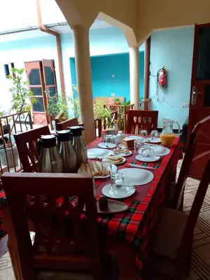 a table with a red table cloth on top of it at Kisanga Homestay in Moshi