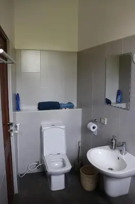 a bathroom with a white toilet and a sink at Themi View in Arusha