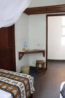 a bedroom with a bed and a table in it at Themi View in Arusha