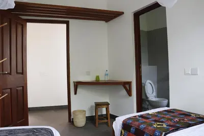 a bedroom with a bed and a toilet and a mirror at Themi View in Arusha