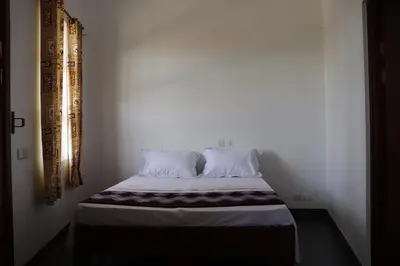 a bed with two pillows on it in a room at Themi View in Arusha