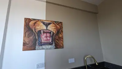 a painting of a tiger with its mouth open at Mufasa city Apartments in Arusha