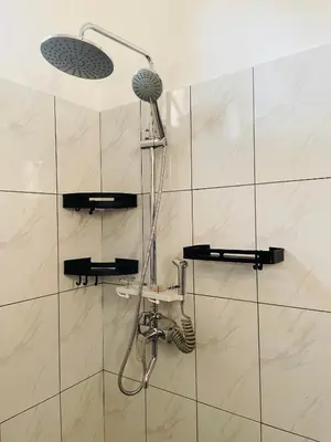 a shower with a shower head in a bathroom at Mufasa city Apartments in Arusha