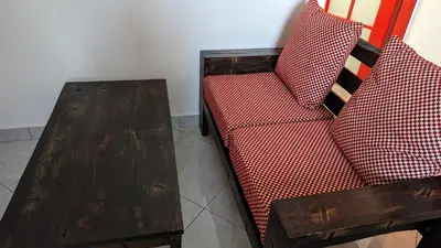 a red couch with a wooden table next to it at Mufasa city Apartments in Arusha