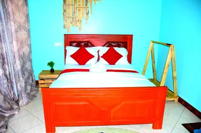 a bed with a red headboard in a room at Safari Park House in Arusha
