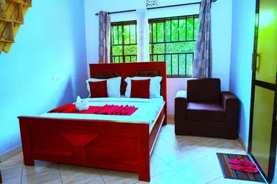 a bedroom with a red bed and a chair at Safari Park House in Arusha