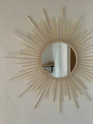 a gold sunburst mirror hanging on a wall at Tiny house with amazing view in Arusha