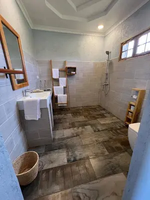 a bathroom with a sink and a toilet and a shower at Heart and Soul Lodge in Karatu