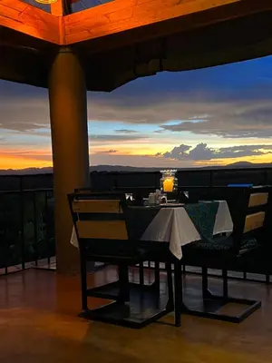 a table and chairs on a balcony at sunset at Heart and Soul Lodge in Karatu