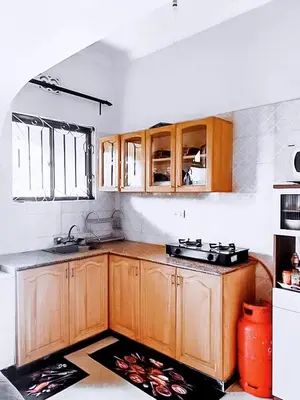 a kitchen with wooden cabinets and a sink at eneyahomes ~ stay with me in Arusha