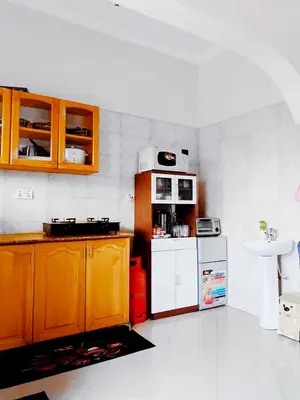 a kitchen with wooden cabinets and a white refrigerator at eneyahomes ~ stay with me in Arusha