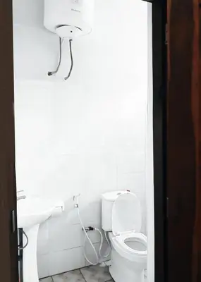 a white bathroom with a toilet and a sink at eneyahomes ~ stay with me in Arusha