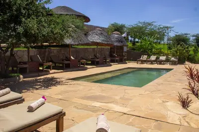a resort with a swimming pool and a resort with chairs at Africa Safari Karatu in Karatu