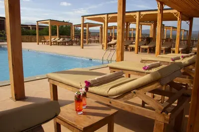 a patio with a pool and a table with a drink at Africa Safari Karatu in Karatu