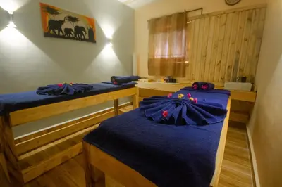 two beds in a room with blue sheets at Africa Safari Karatu in Karatu