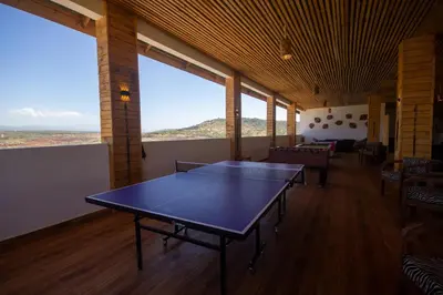 a ping pong table in a room with windows at Africa Safari Karatu in Karatu