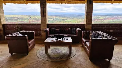 a living room with couches and a cat on a table at Africa Safari Karatu in Karatu