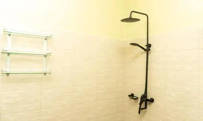 a shower with a glass door and a shower head at Kiteme Comfort Lodge in Arusha