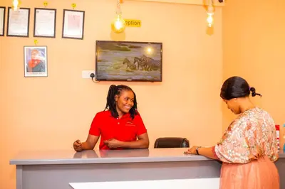a woman standing at a counter in a room at Kiteme Comfort Lodge in Arusha