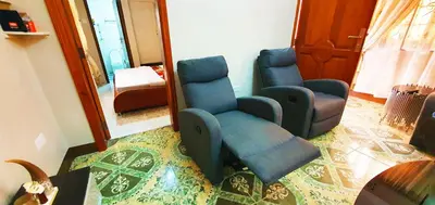 a living room with two chairs and a mirror at Goodhope 3-Bedroom Vacation Rental in Arusha