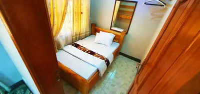 a small bedroom with a bed and a mirror at Goodhope 3-Bedroom Vacation Rental in Arusha