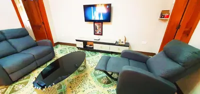 a living room with a couch and a tv at Goodhope 3-Bedroom Vacation Rental in Arusha